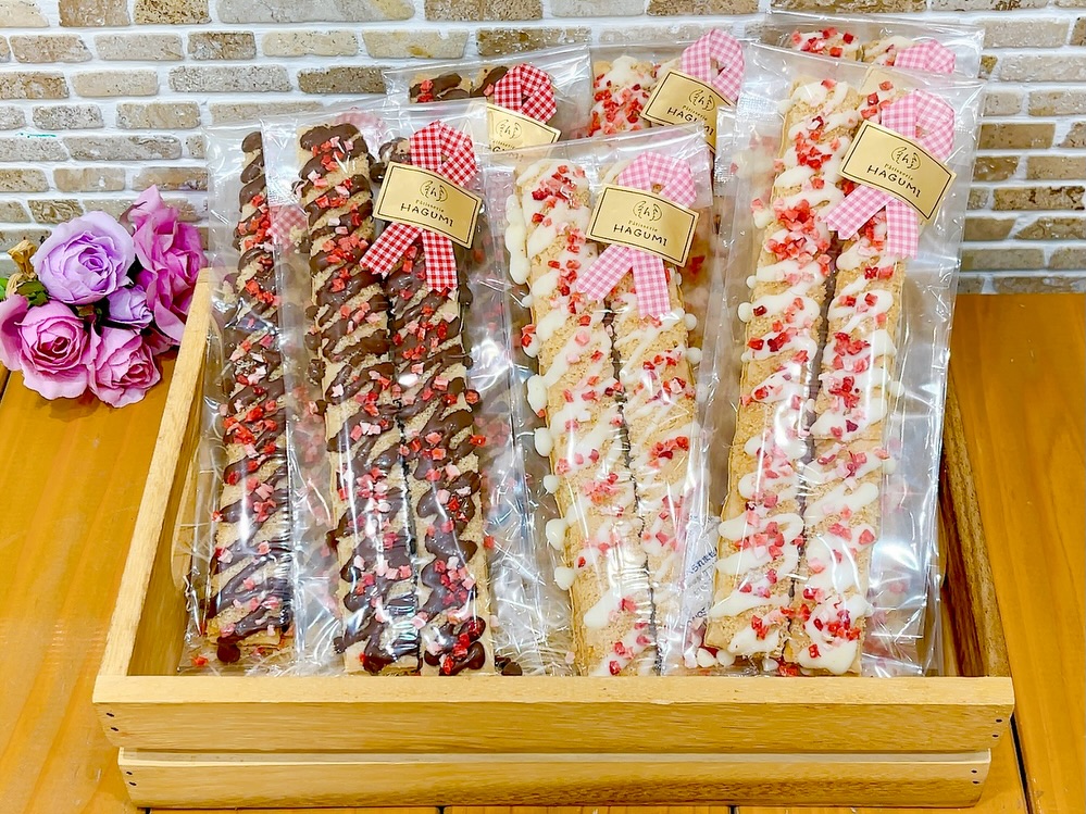 今年から新登場の️スイートパイ️店頭に並んでいます砂糖をまぶして焼いたサクサクのパイにチョコレートとドライ苺をまぶしたバレンタイン限定スイーツ 🤎ミルクチョコ と🤍ホワイトチョコの2種類ご用意しています♬ チョコレートに苺の組み合わせが可愛すぎて、ついつい苺増し増しでお作りしてしまいました…️(苺を乗せすぎて完成品を見たシェフがちょっと焦っておりました) ということで、たっぷり苺が付いているのを見つけたら是非お手に取ってみてください #スイートパイ #スティックチョコパイ #バレンタインギフト #松戸ケーキ屋 #パティスリーはぐみ